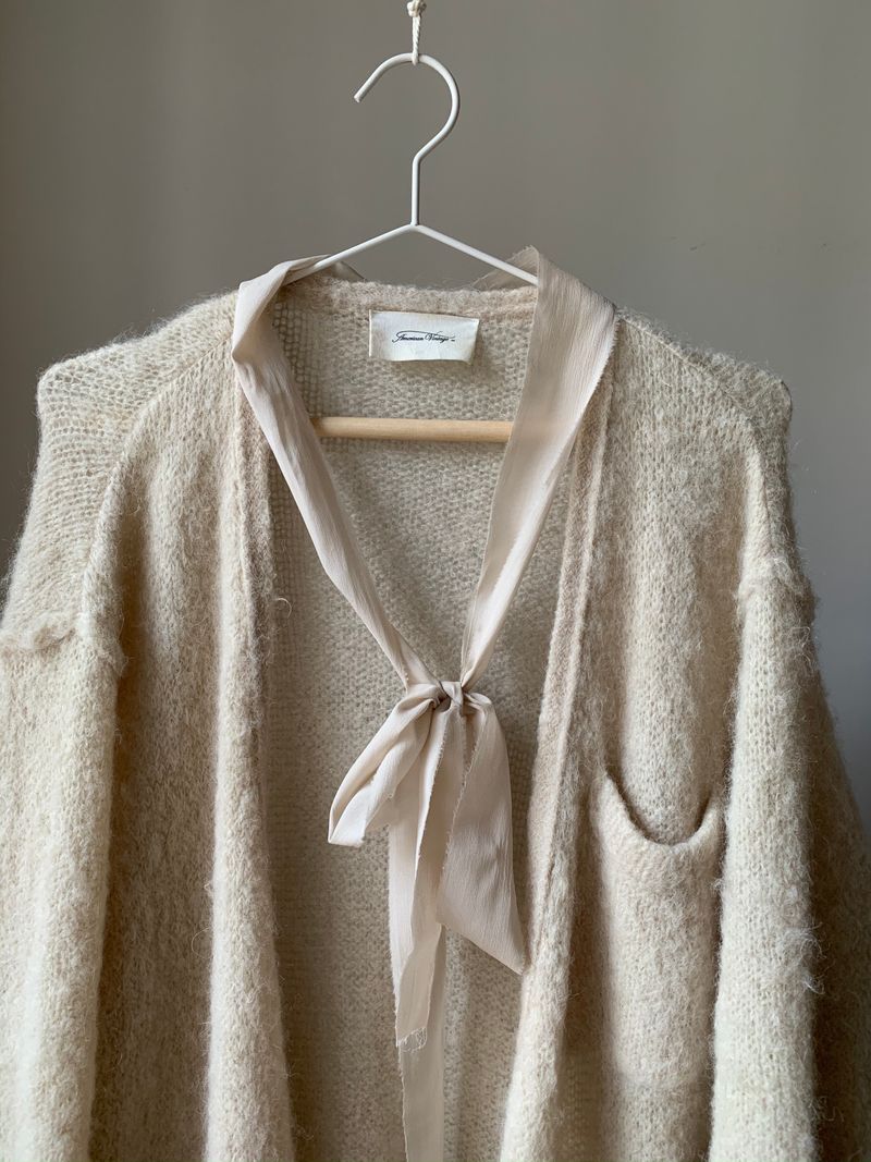 Warm cream tie-front cardigan on a hanger
