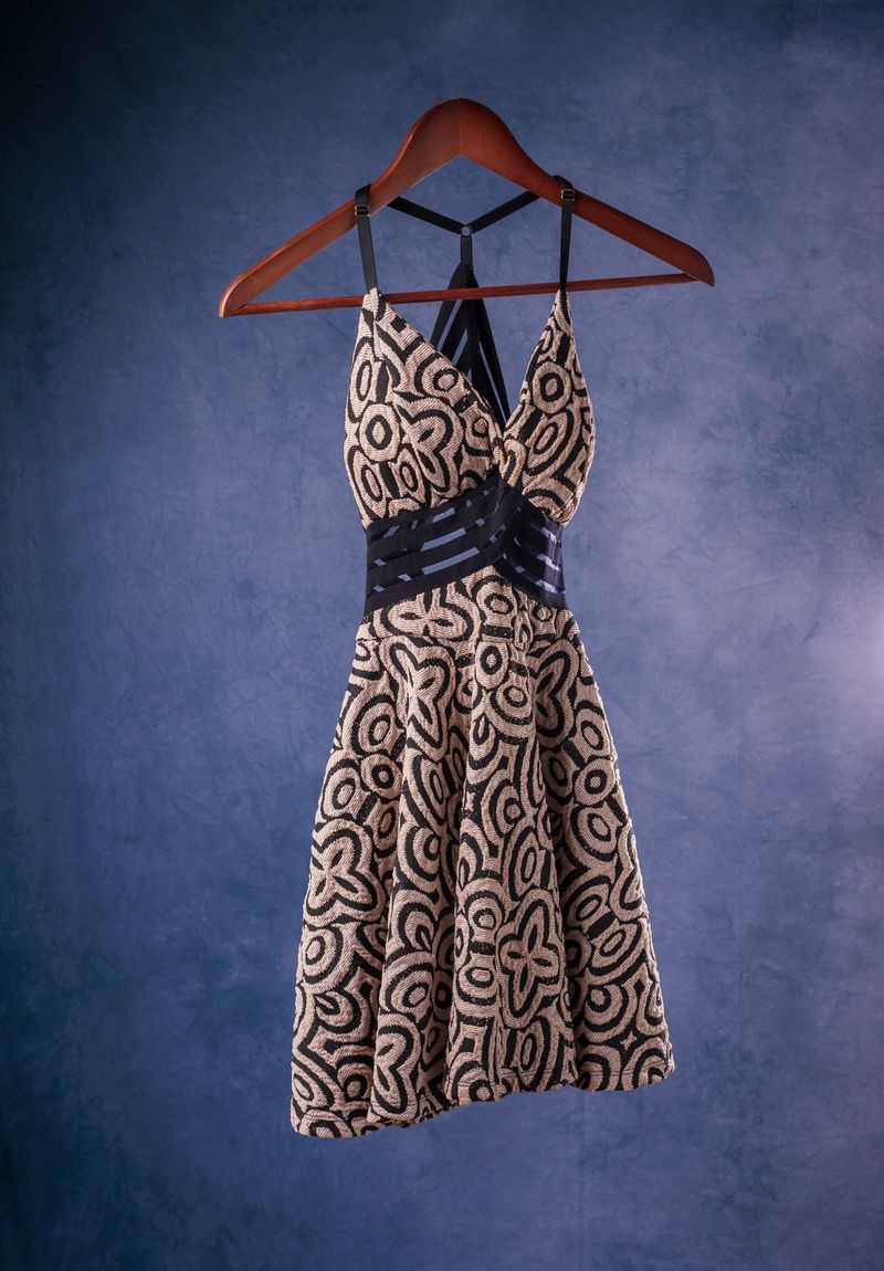 Black-and-cream sleeveless printed dress on a hanger