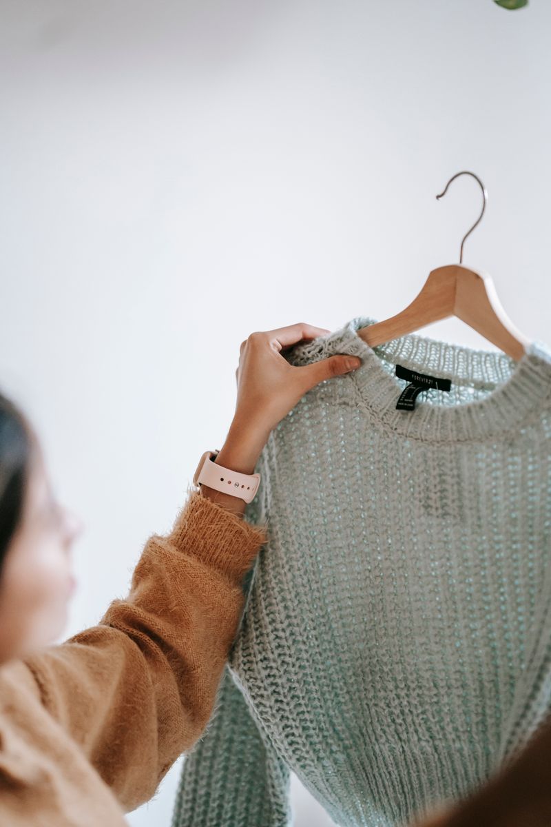 Sage-green sweater on a hanger